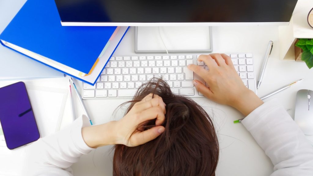 PC前で頭を抱えている人