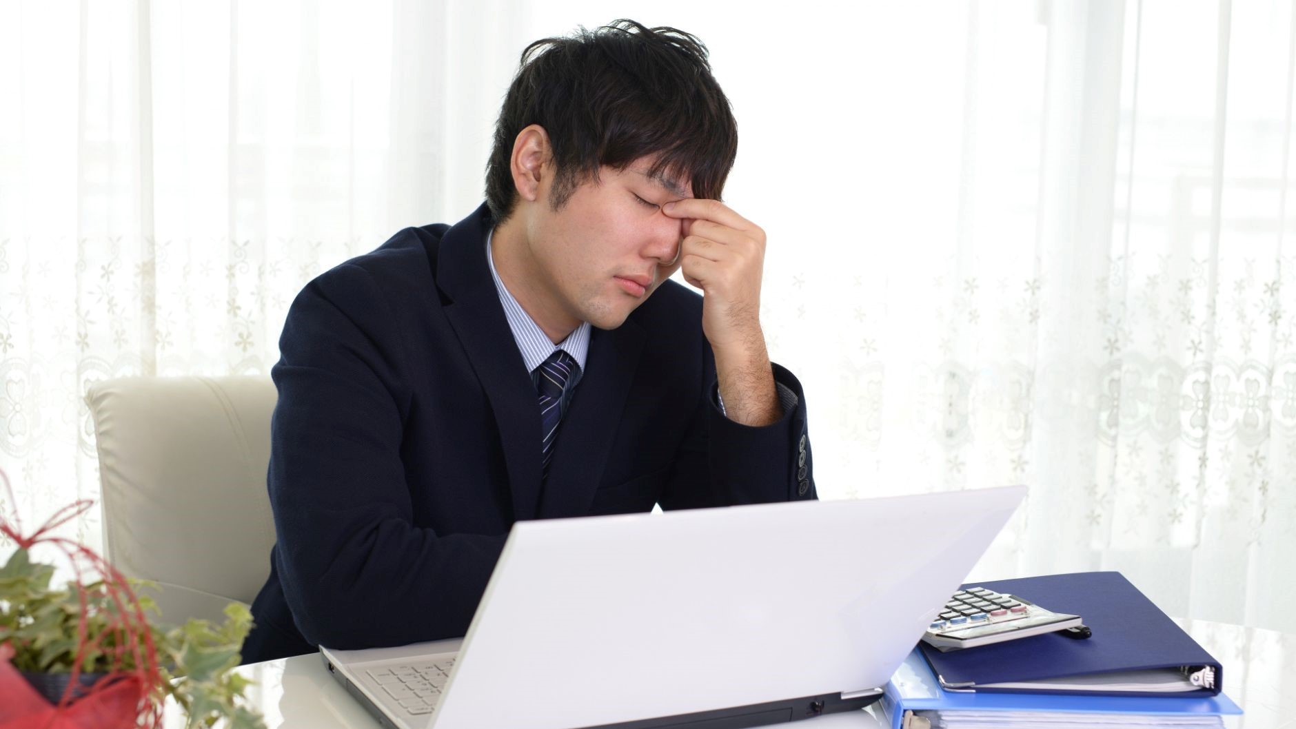 目頭を押さえる男性
