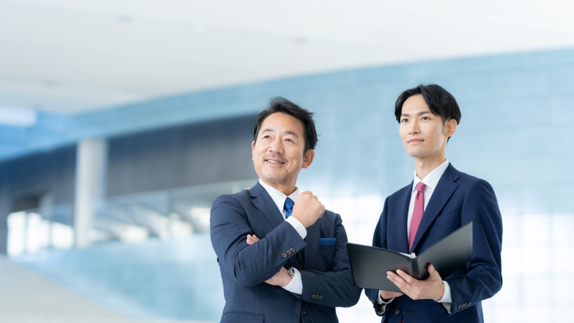 バインダー、男性2名、スーツ、オフィスビルの中