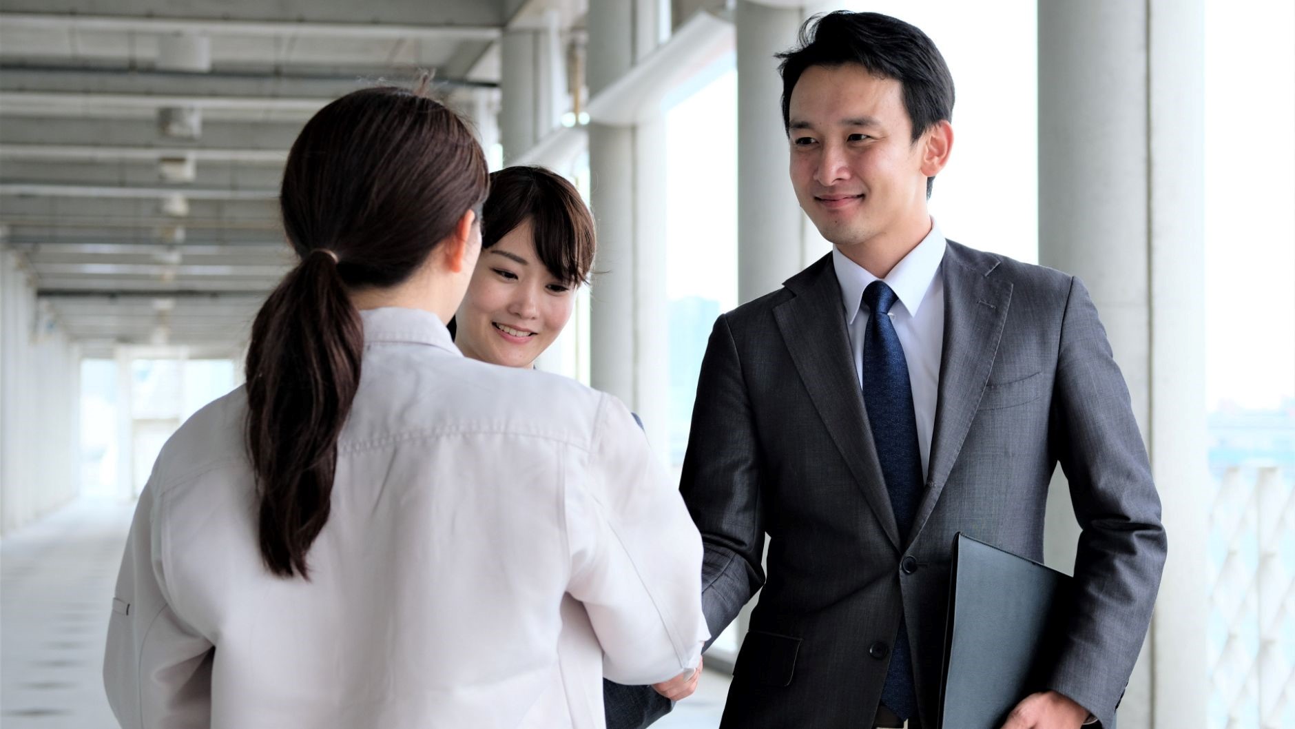 女性2名、男性1名、握手