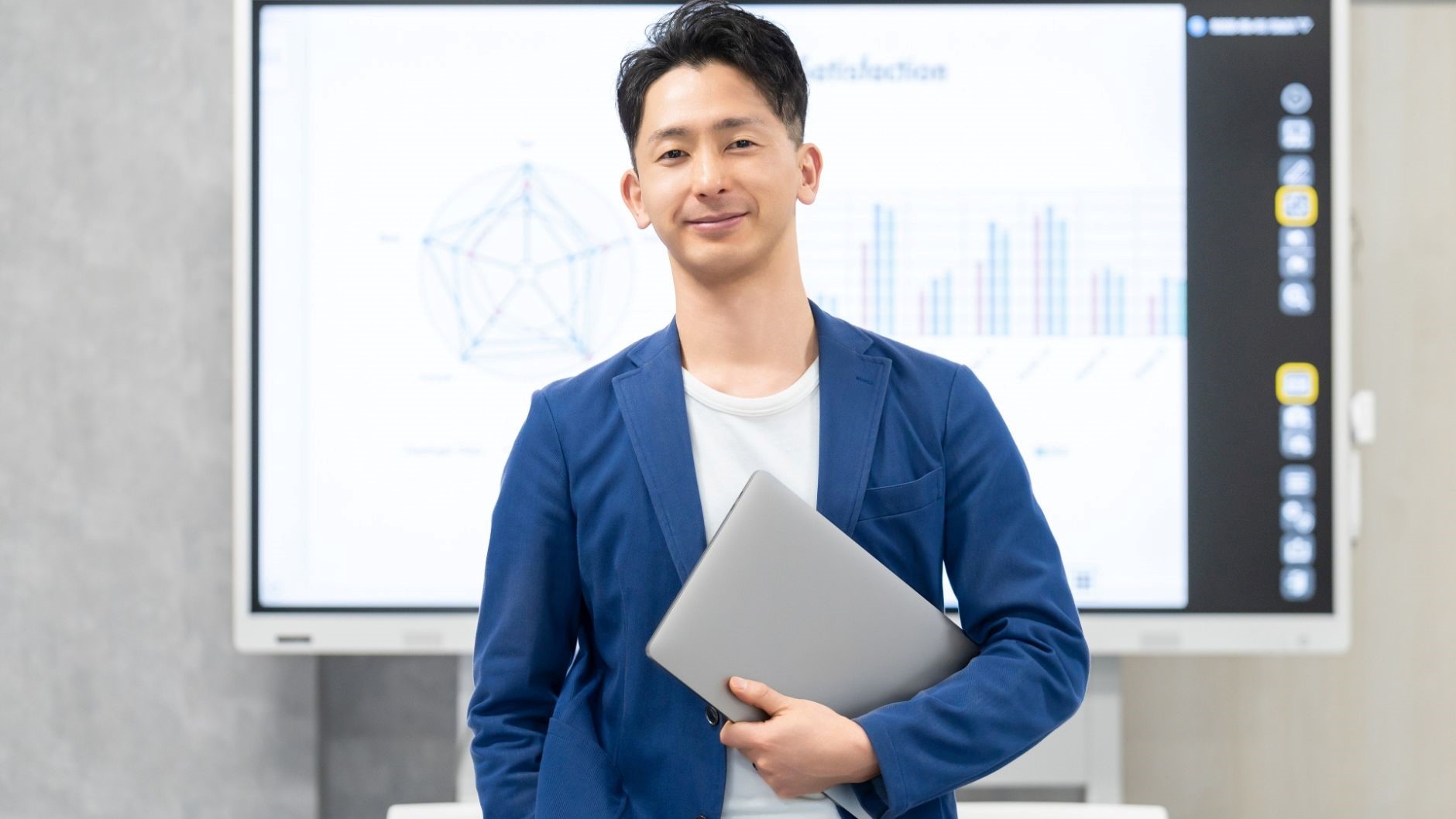大きいモニター、グラフ、PC抱えた男性