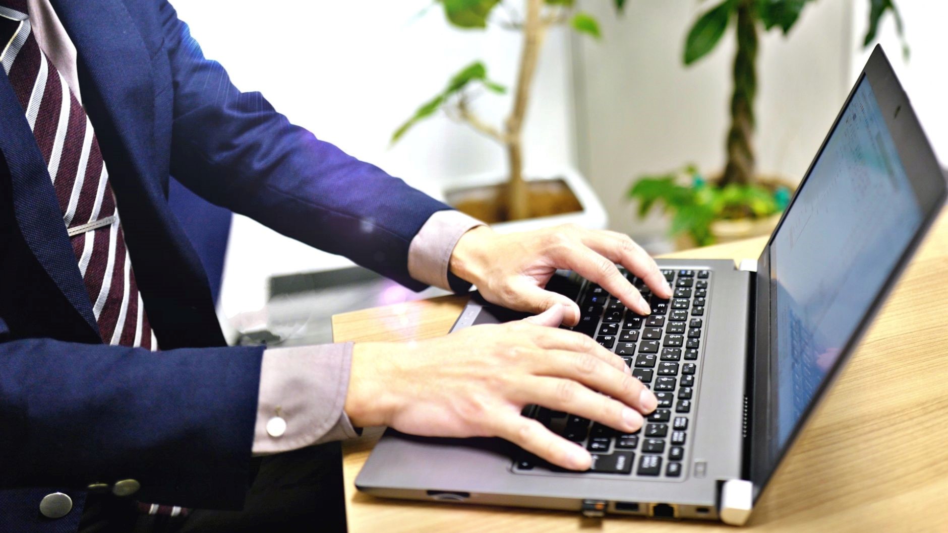 年収1000万のエンジニアになるためにPCで調査や実践をしているスーツの男性