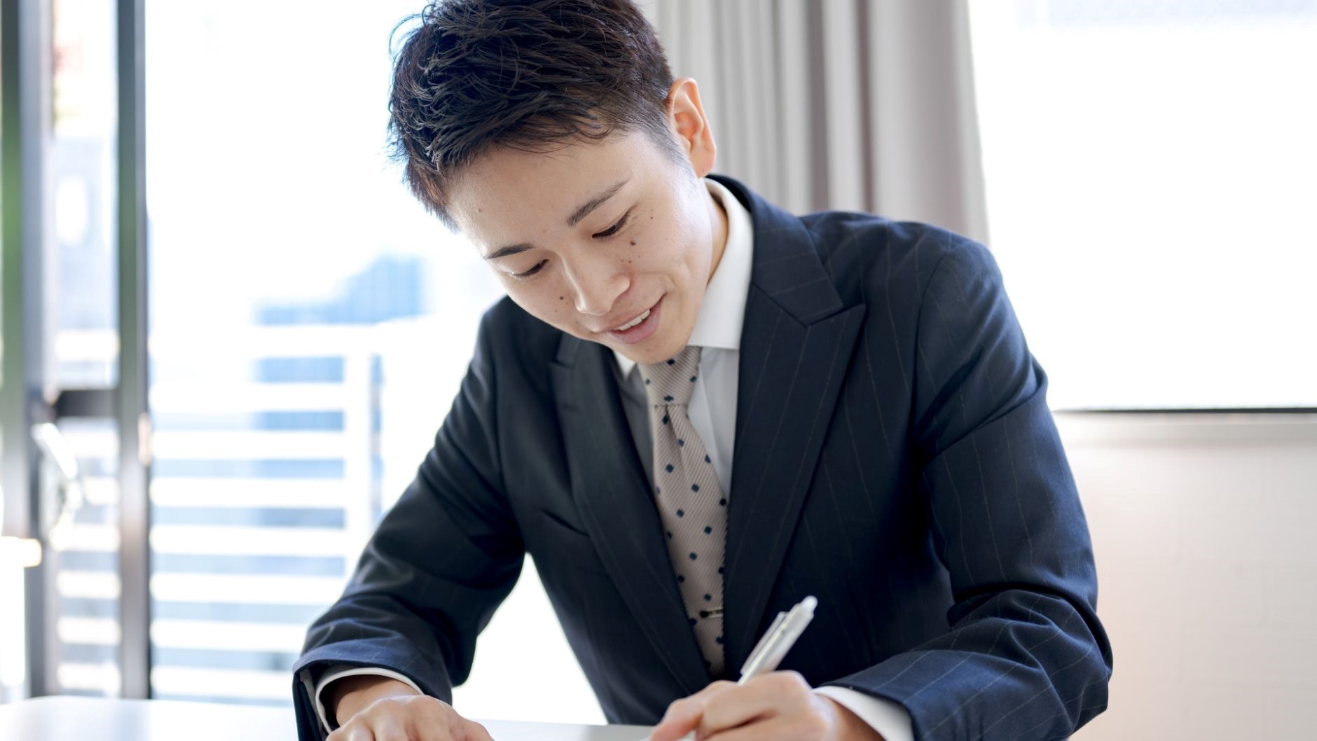 年収1000万を達成しているエンジニアに共通するスキルを書き出している男性
