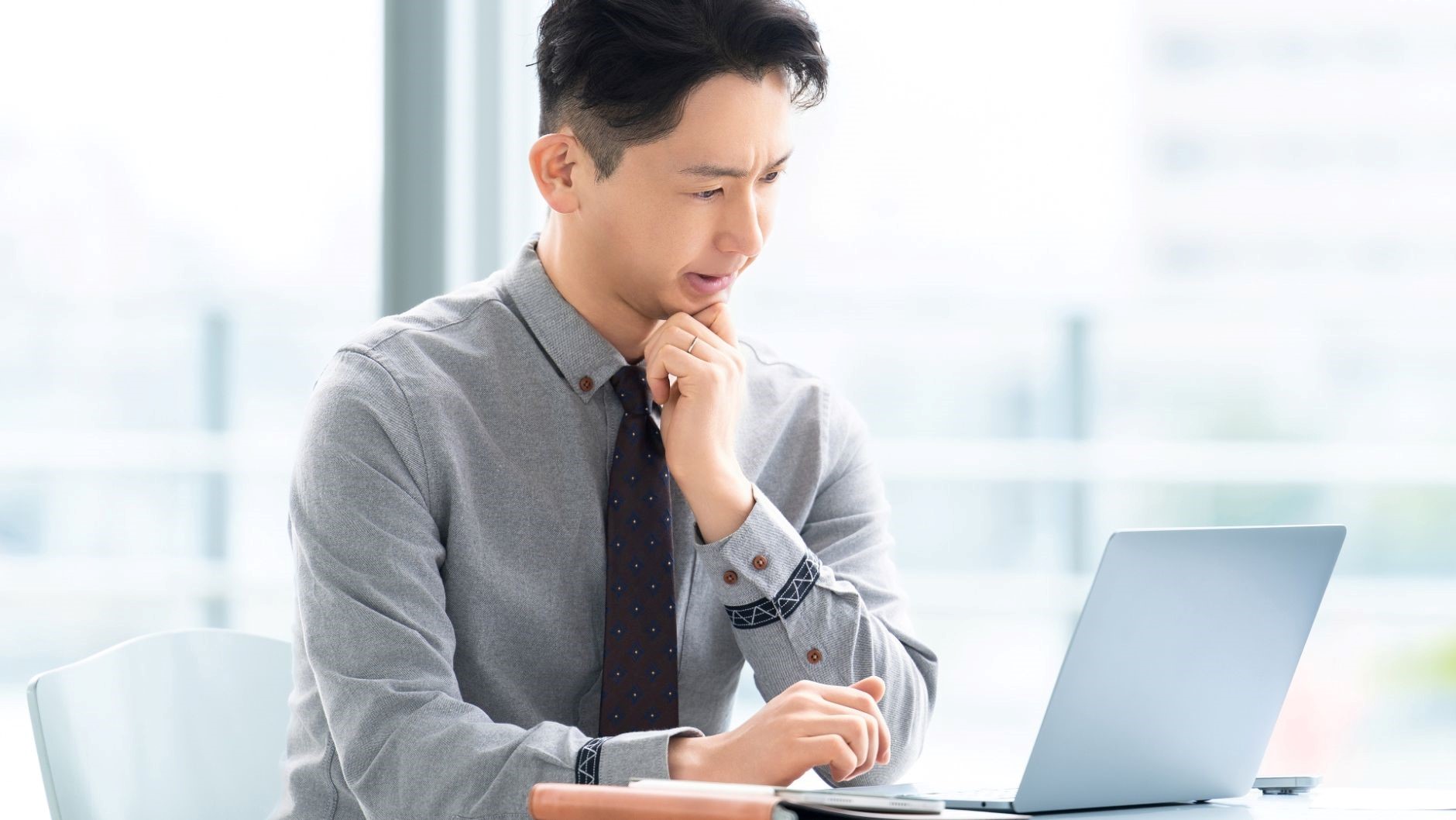 年収1000万を目指す際に注意すべきポイントを調べて考え事をしている男性