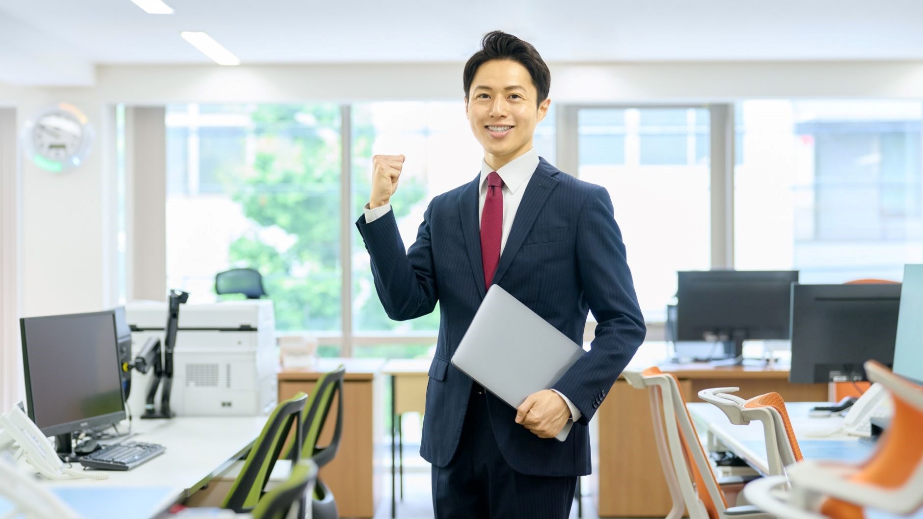 オフィス、将来性と市場価値にガッツポーズするスーツの男性、