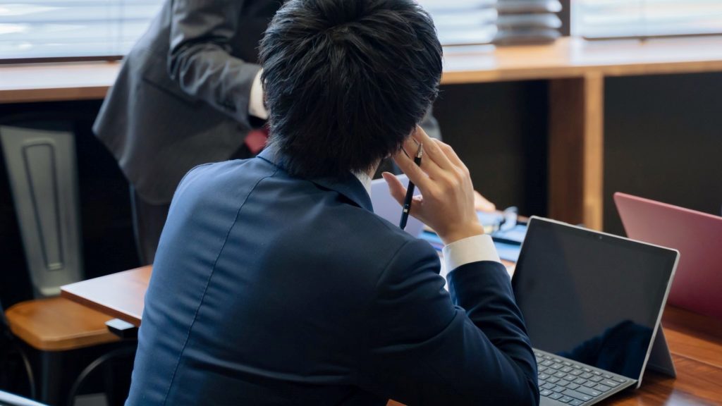 話し合いをする男性の後ろ姿