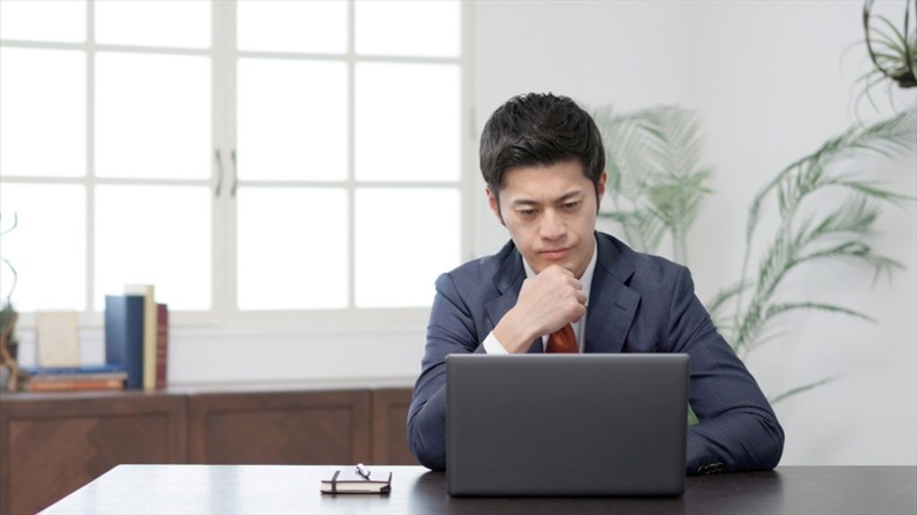 PCの前で考える男性
