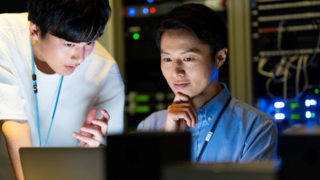 PCの前で相談をする二人の男性