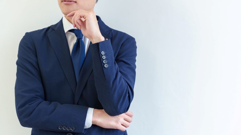 顎に手を添えて考える男性