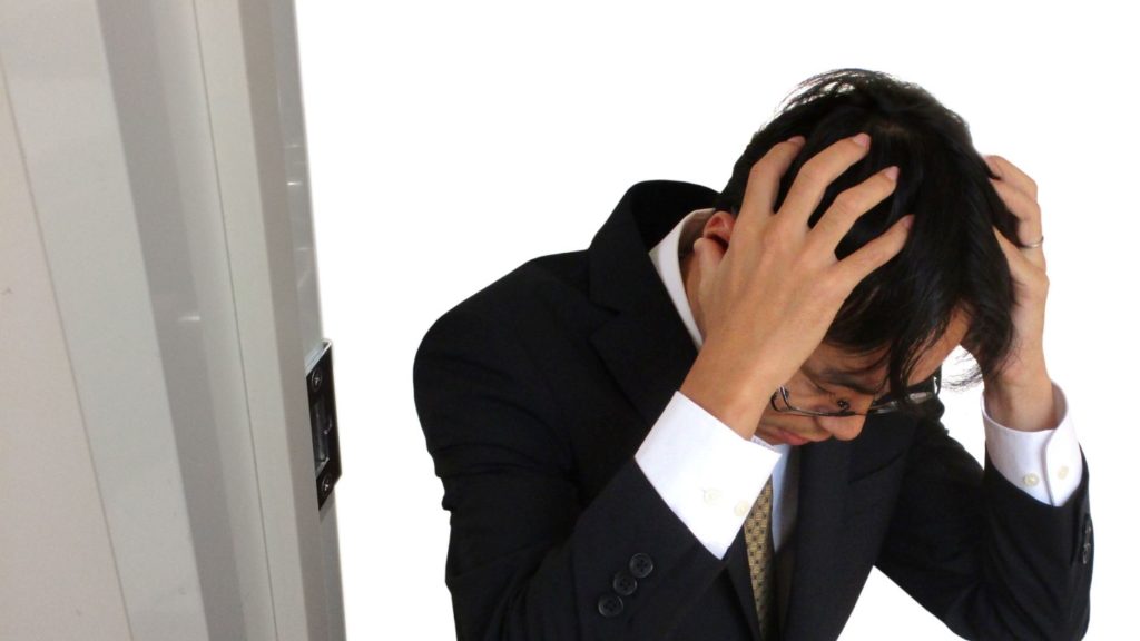 頭を抱える男性